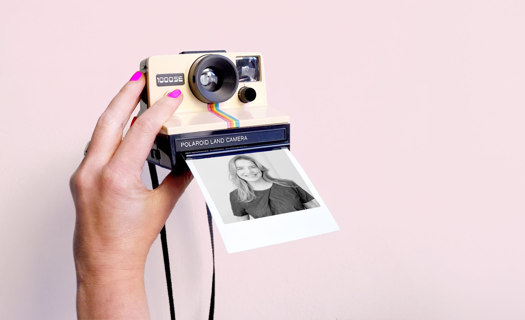 Hand die eine Polaroid Kamera hält